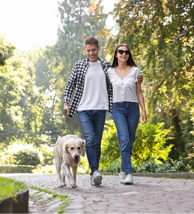 Couple walking with dog in Fika community in Elgin, TX.