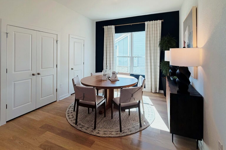 Dining room with round table and chairs in Fika community in Elgin, TX.