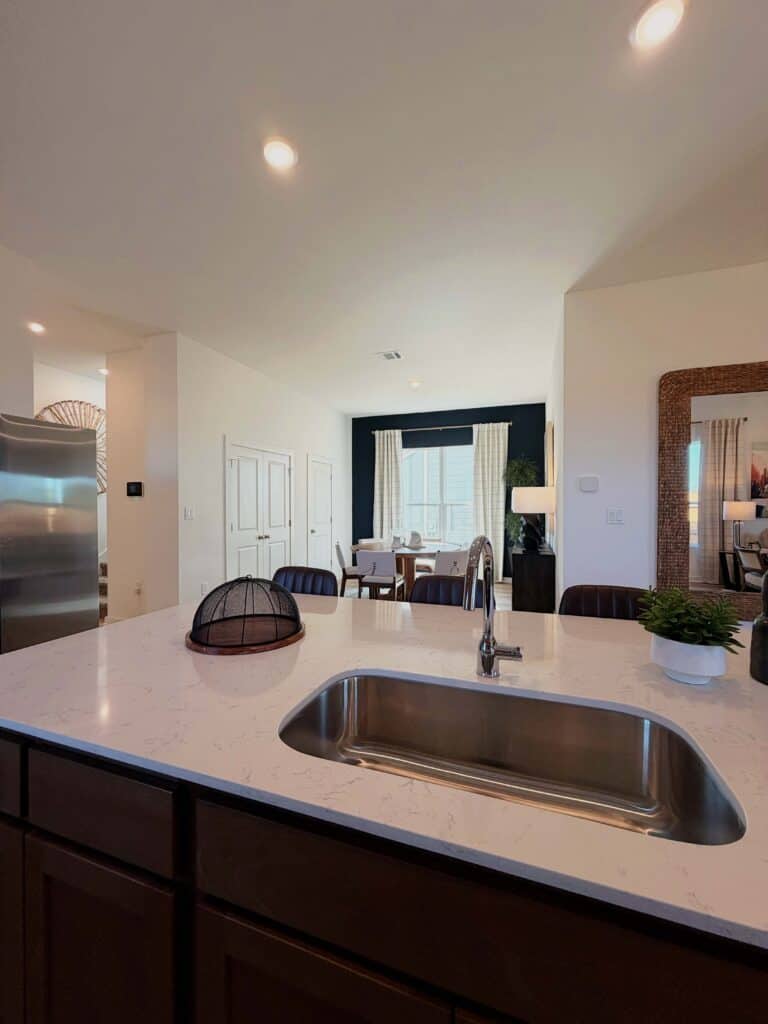 Open kitchen with island and dining space in Fika community in Elgin, TX.