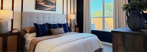 Bedroom interior with bed, pillows, and window in Fika community.