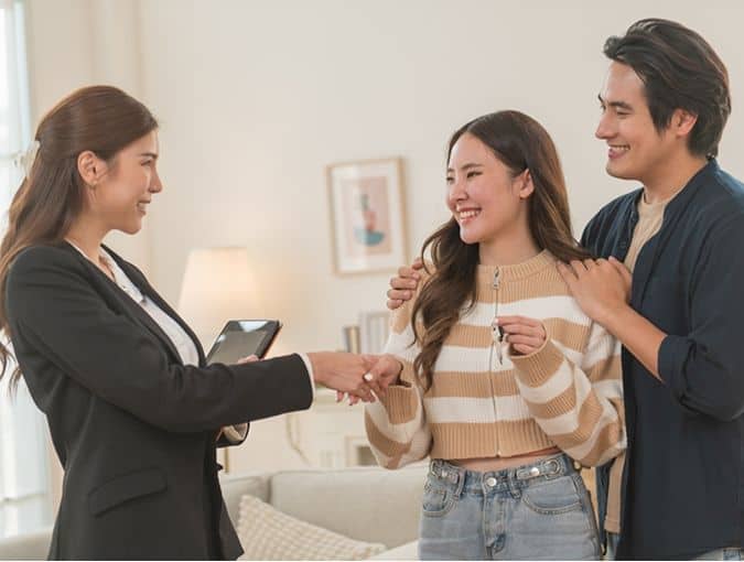 Realtor shaking hands with a couple in a living room in Elgin, TX.