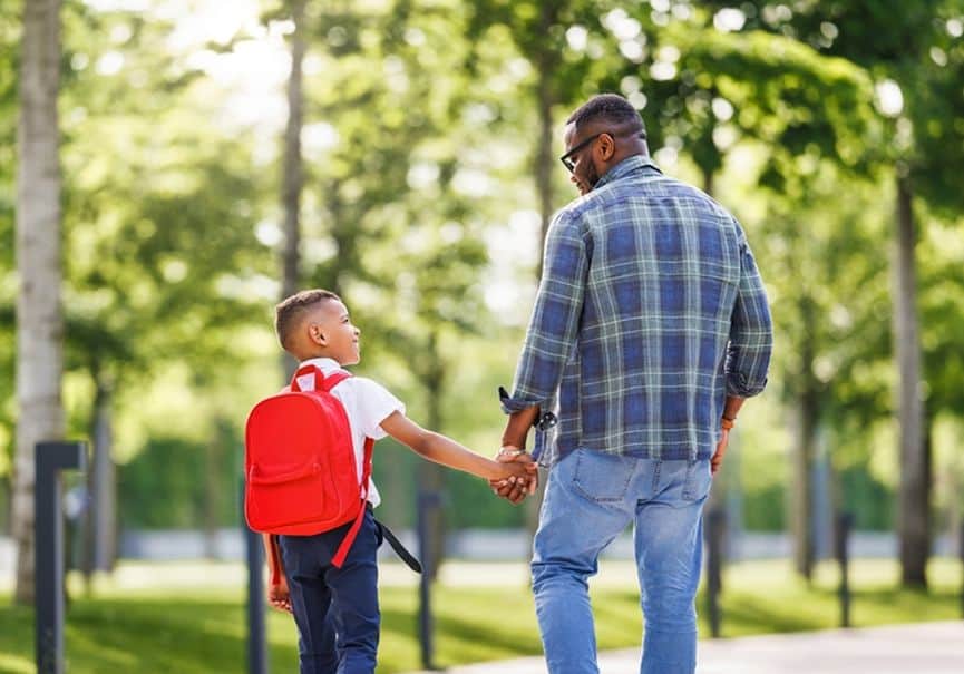 Father and son shaking hands in a park at Fika in Elgin, TX.