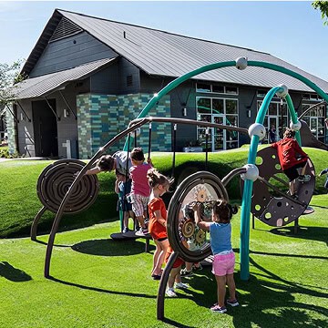 Children playing on a colorful playground at Fika in Elgin, TX.